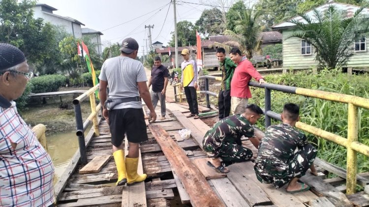 Perkuat Kemanunggalan TNI dan Rakyat, Satgas TMMD ke-129 Kodim 0313/KPR dan Warga Gotong Royong Perbaiki Jembatan jalan Desa